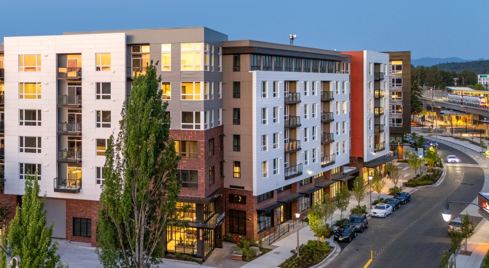 a street and a building with trees at dusk